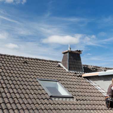 A residential roof with brown asphalt shingles installed in a neat, overlapping pattern.