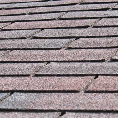 A close-up view of asphalt roof shingles arranged in overlapping rows
