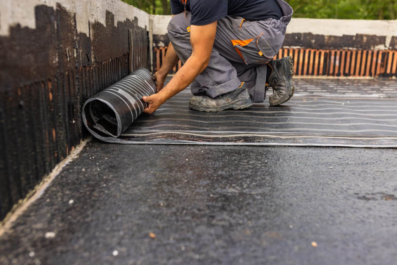 Worker laying the vapor barrier for the roof, bituminous membran