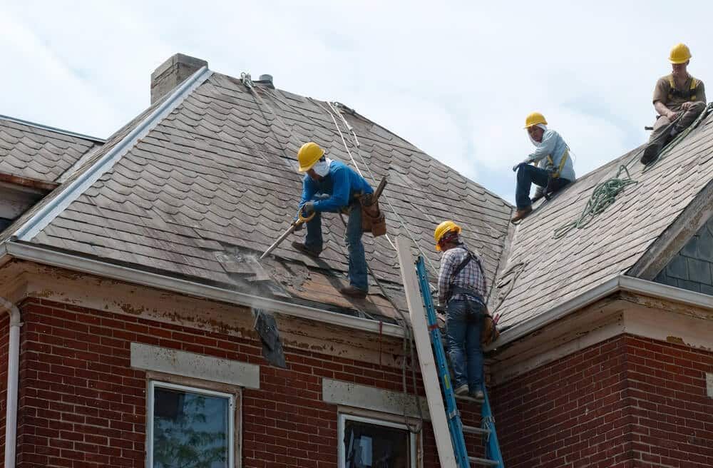 Professional workers removing old shingle roof