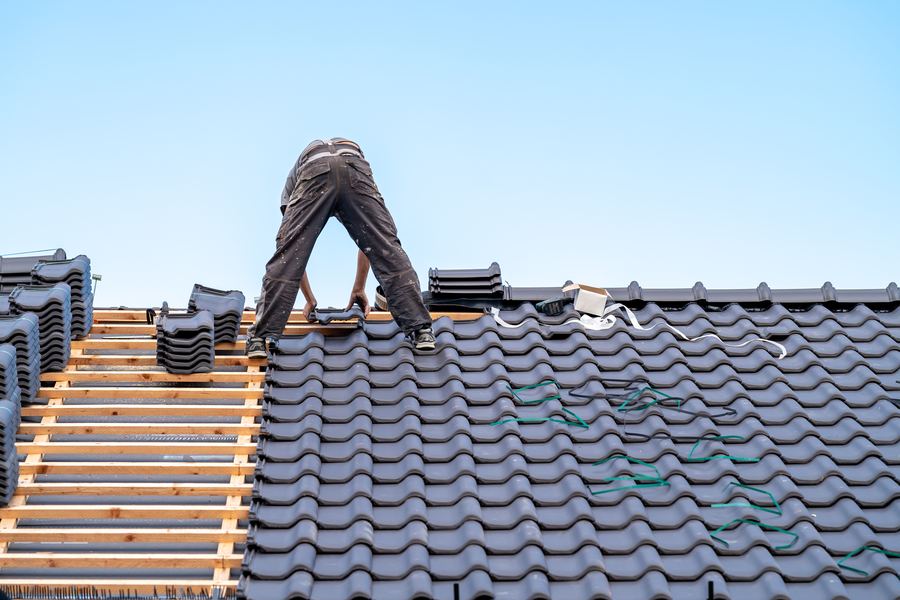 Roofer repairing a damaged section of roof