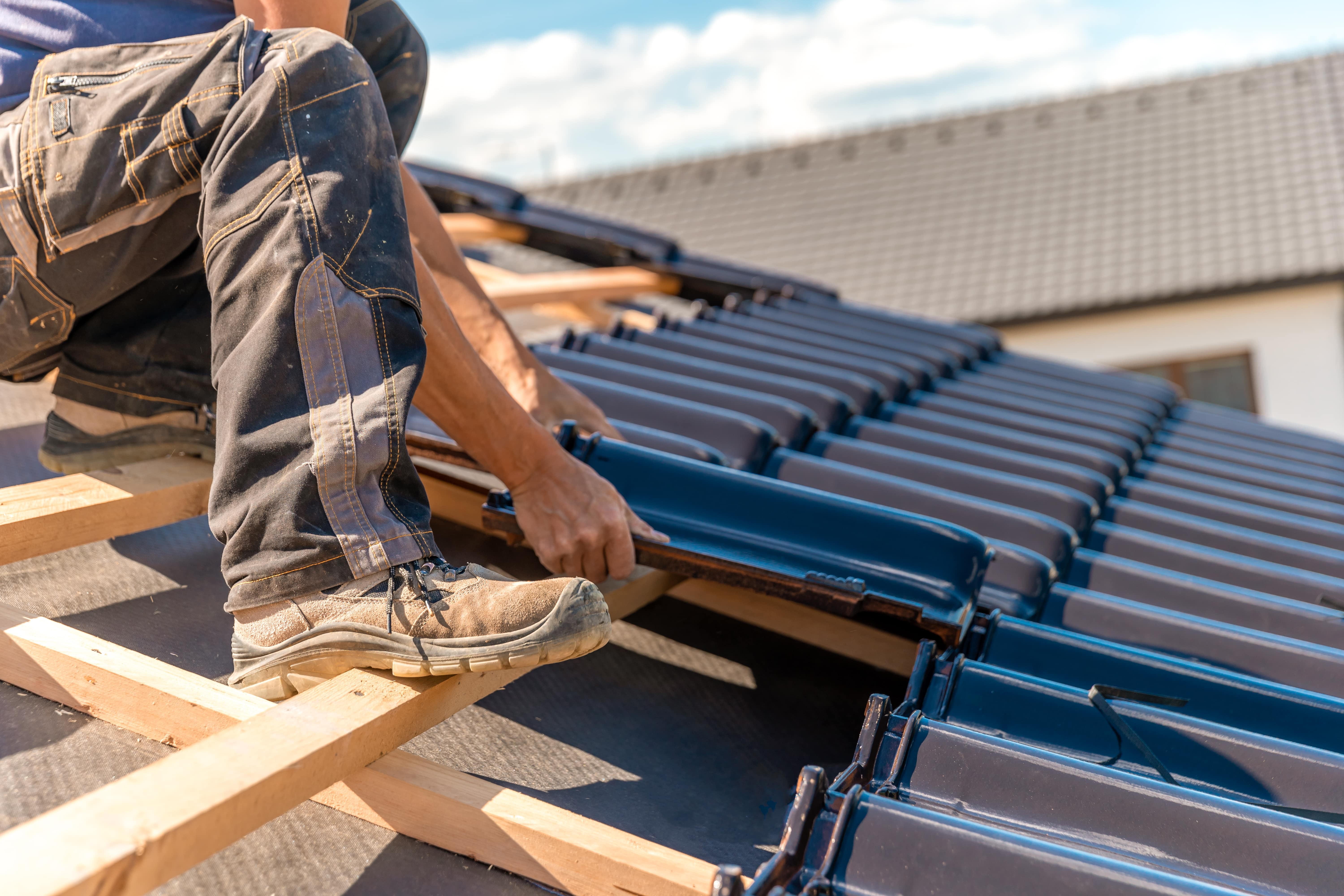 roof contractor installing tile roof close up