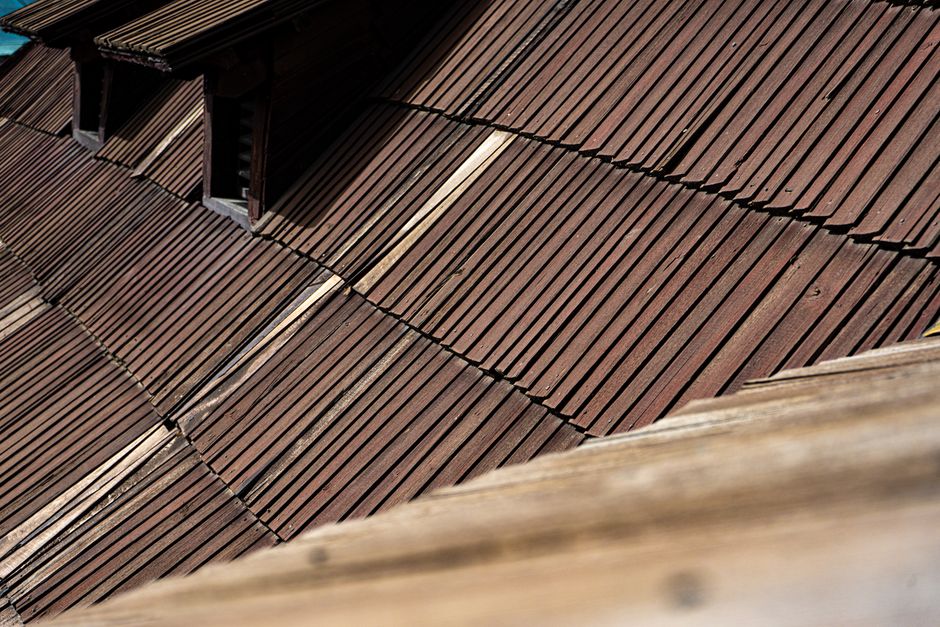 Detailed close-up of aged wooden roof shingles showing texture and wear