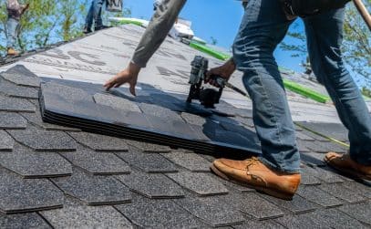 Roofing crew installing new asphalt shingles during a roof replacement on a New Orleans home
