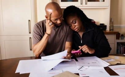 Couple reviewing household budget and roof financing options together at their kitchen table