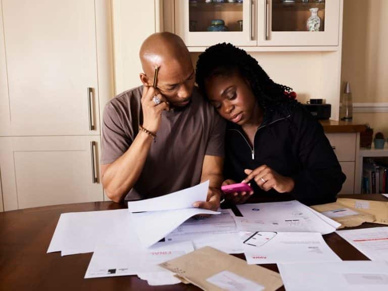 Couple reviewing household budget and roof financing options together at their kitchen table