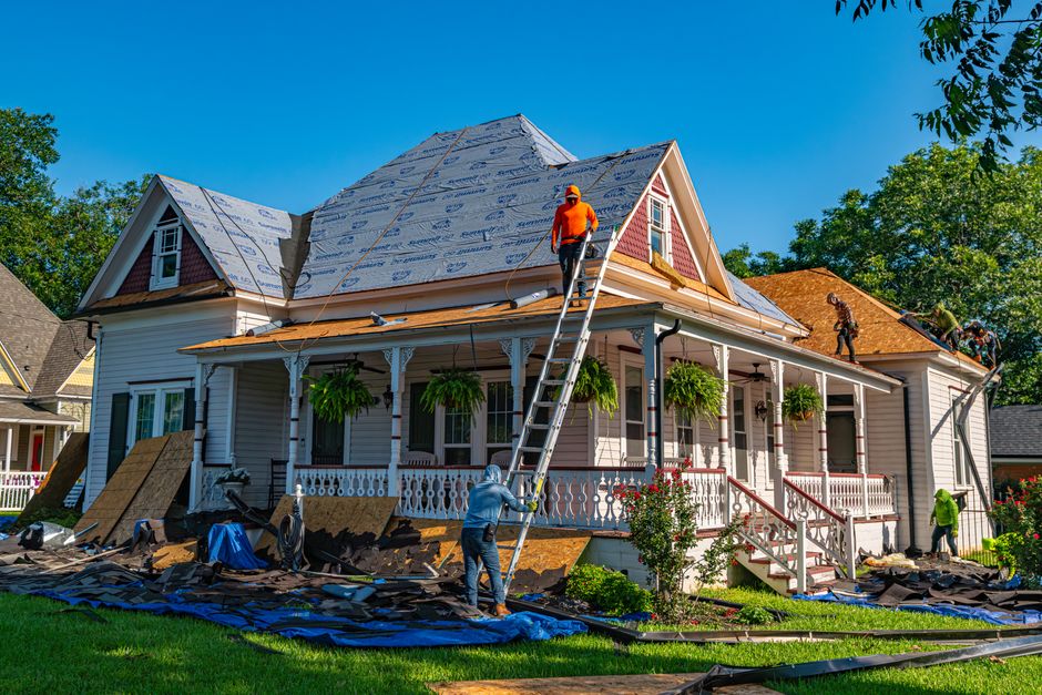 Roofing crew installing a new roof replacement during a home roofing project