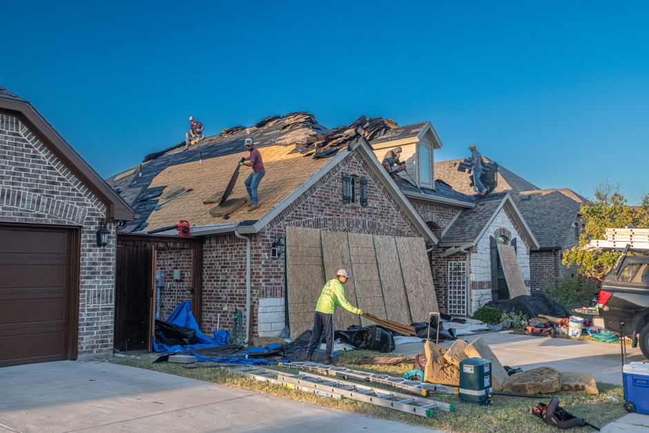 Roofers replacing more than half of a residential roof, triggering the New Orleans 50 percent permit rule