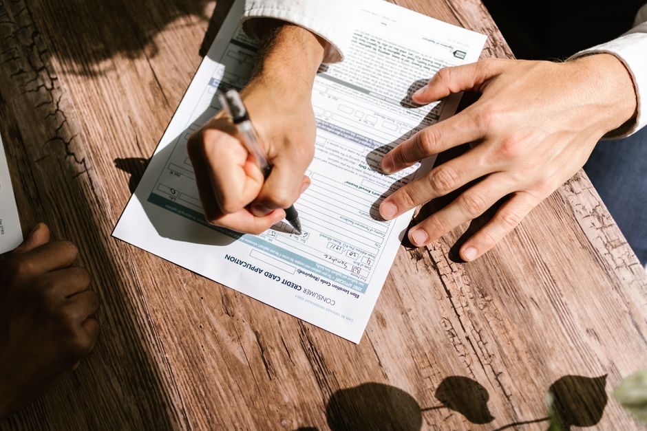Homeowner signing a loan application form to finance a roof replacement